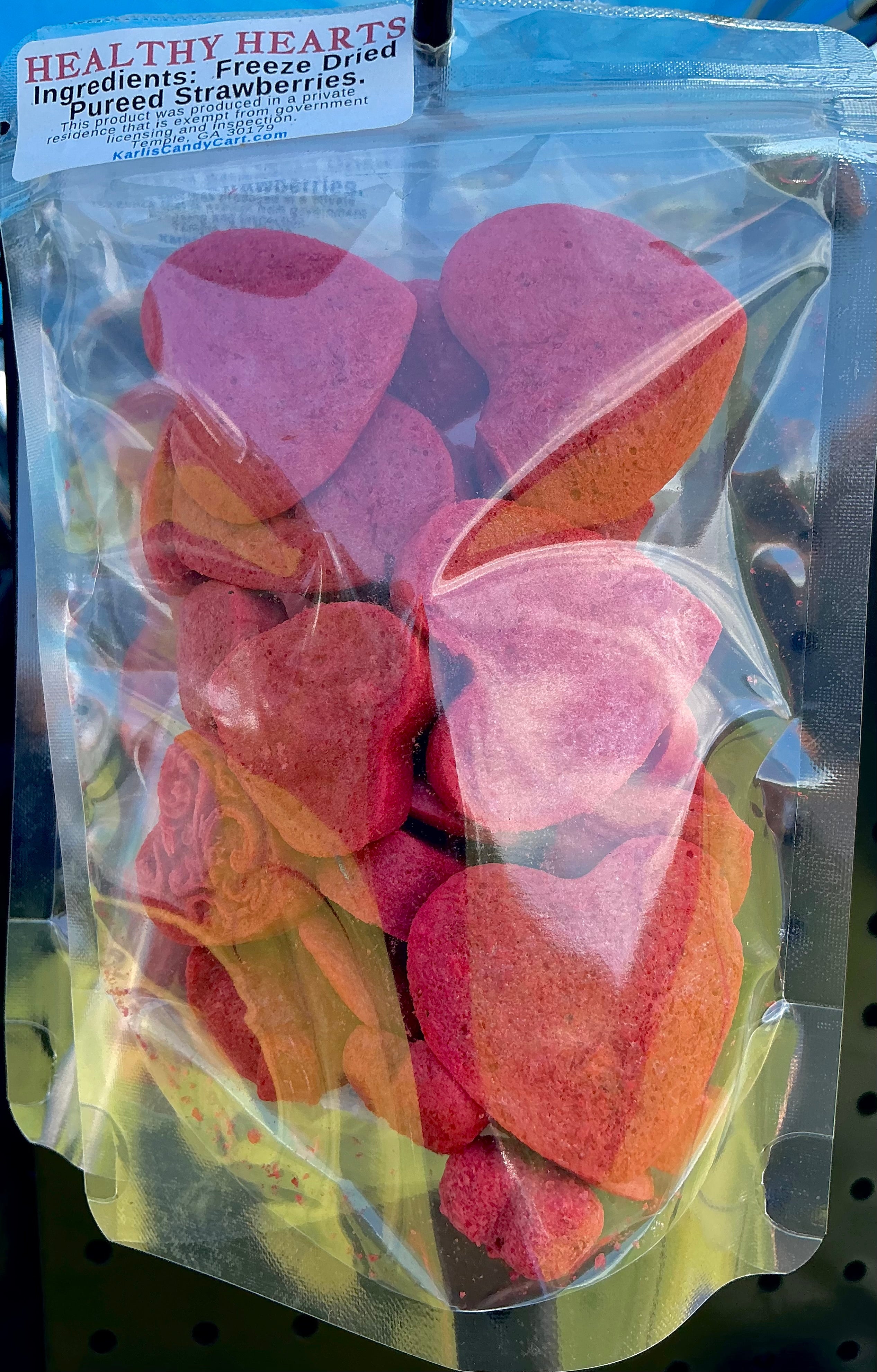 Packaged freeze-dried strawberry hearts with a visible brand label.